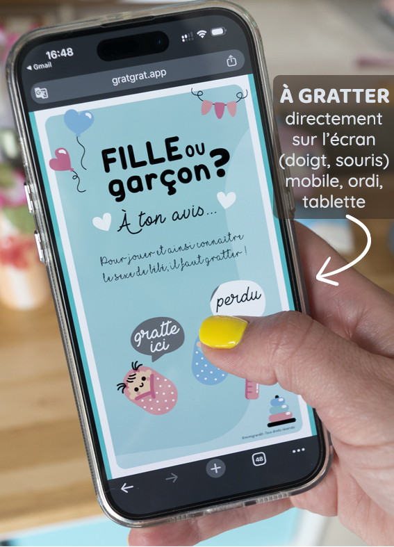 Exemple de carte à gratter en ligne sur l'écran d'un téléphone pour deviner le sexe de bébé. Une main tenant un smartphone qui affiche une carte à gratter en ligne d'annonce de grossesse avec le texte « Fille ou garçon ? À ton avis... », un doigt posé sur l'écran tactile.